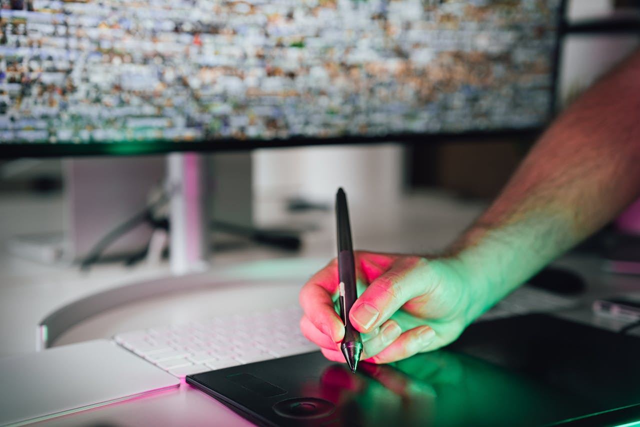 our-experience A digital artist using a graphics tablet and stylus in a modern workspace. High-tech creative process.