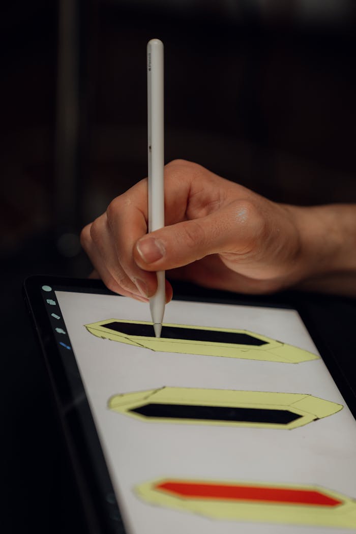 gallery-6 A person using a stylus pen to draw geometric shapes on a digital tablet screen.