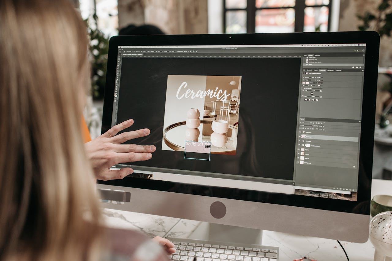 why-choose-us A graphic designer works on a ceramics promotion using Adobe Photoshop on an iMac.